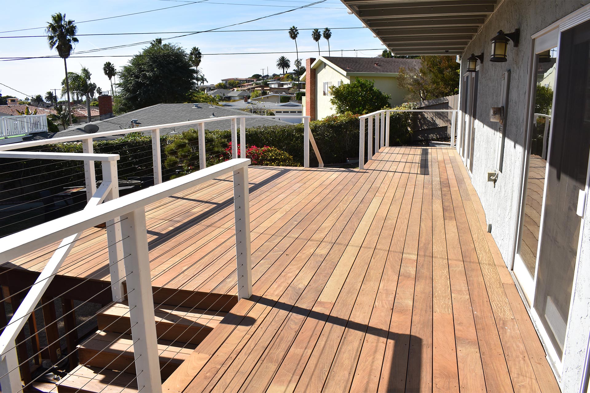 large wooden deck beneath palm trees