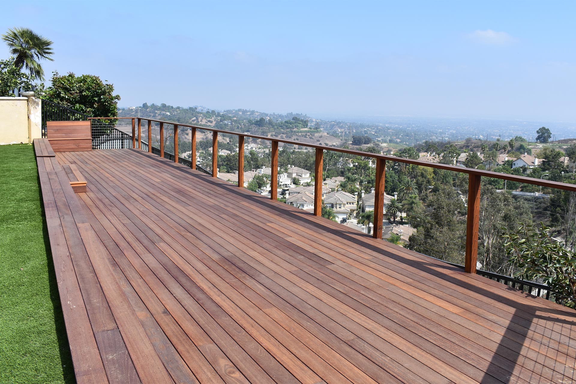broad wooden backyard deck overlooking a sunny city