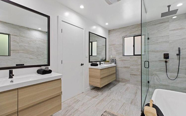 clean modern bathroom with two sinks and glass walled shower