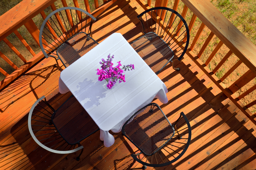 cafe table with four chairs on wooden deck