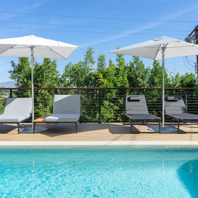 Poolside deck with chaise lounge chairs and umbrellas