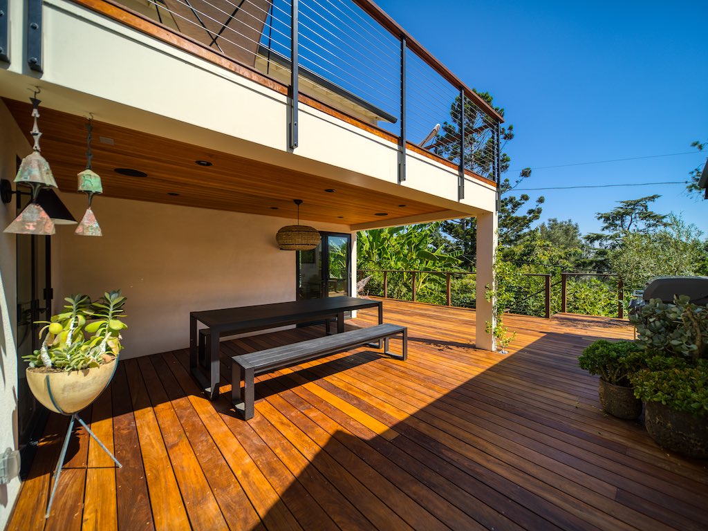 Two-story wooden deck with covered seating