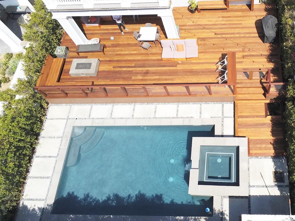 Bird's eye view of a custom wooden deck perfectly fitting a pool and hot tub