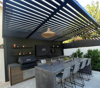Durable and attractive pergola by MG Construction & Decks over a sophisticated outdoor grill and bar seating area